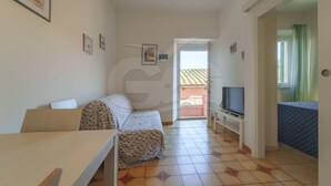 A small, bright room with a bed, a TV, and a balcony. - NEL CUORE DI RIO MARINA (Rio Marina)