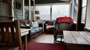 A cozy room with a wooden bench, a small table, a sofa, and a chair.