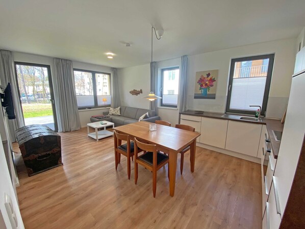 Un appartement moderne comprenant un coin repas, une cuisine et un salon.