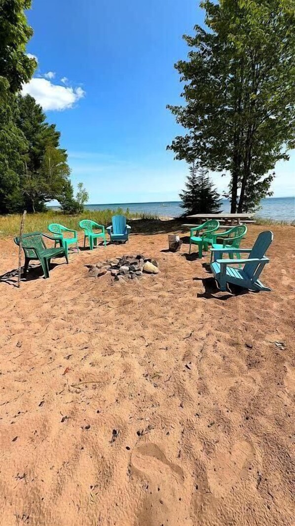 A beach setting with outdoor seating and a fire pit. - 400 Feet Sugar Sand Beach - Barge Bay (La Pointe)