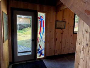 A wooden interior with a door leading to an outdoor area.