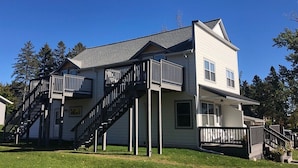 Une maison à deux étages avec un balcon, un escalier et une véranda à l’avant.
