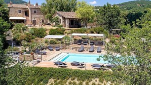 A stone building with a pool, surrounded by greenery and hills. - Villa Cenobio D: A characteristic and welcoming apartment that is part of an ancient country house made of stone, with Free WI-FI. (Umbertide)