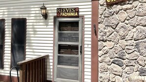 Un edificio con pared de piedra y puerta metálica con la leyenda "REEVES PACHANGA".