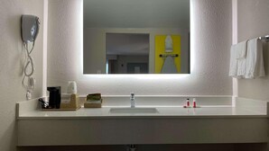 A bathroom with a large mirror, a sink, a coffee maker, and a towel rack. - Homelodge Newnan (Newnan)