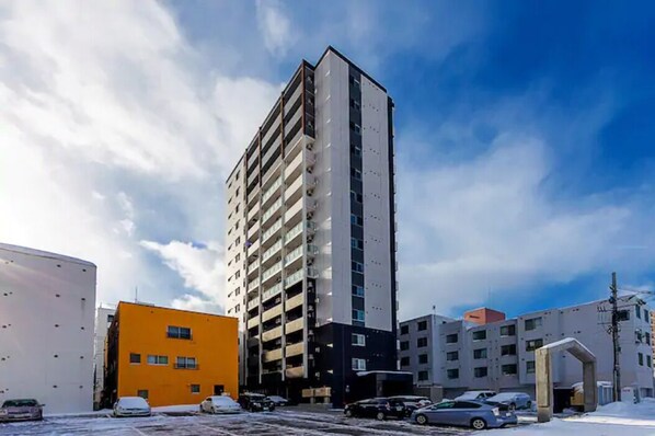 A multi-story building with a modern design, featuring a mix of balconies and windows.