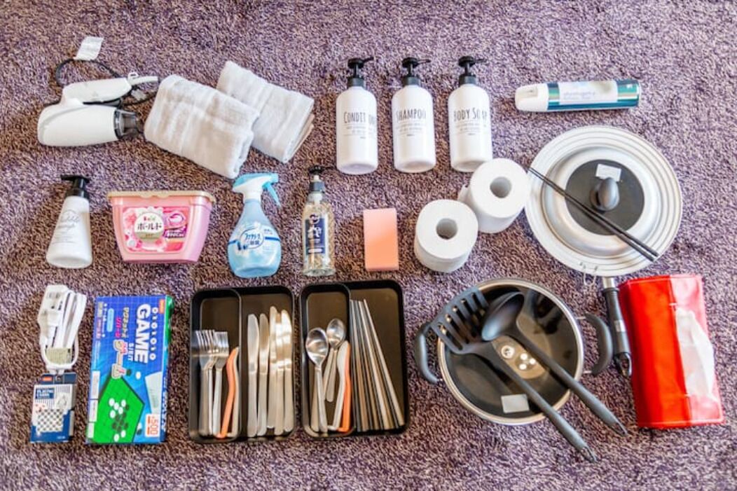 A variety of toiletries and personal care items laid out on a carpeted floor.