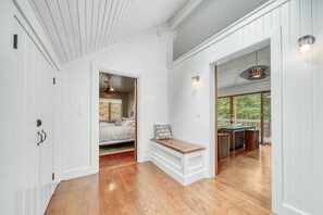 Relax in a bright and airy space with a comfortable bed, bench seating, and a doorway leading to a balcony with an outdoor view.