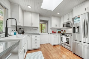 Prepare meals in the well-equipped kitchen with a central island, sink, microwave, and refrigerator.