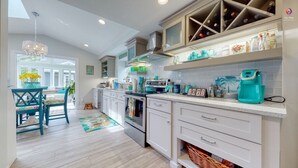 Una cucina moderna con mobili bianchi, forno integrato e angolo caffè.