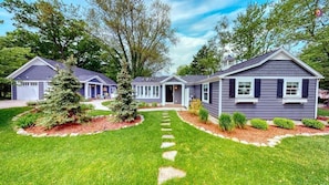 A residential house with a front yard, a driveway, and a pathway leading to the entrance.