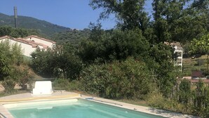 A rectangular swimming pool with a tiled edge, surrounded by a patio area with white lounge chairs. - Bas de Villa,piscine,calme,sécurisé, Ajaccio (Ajaccio)