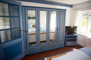 A bedroom with a bed, a wardrobe, a television, and a window. - FW Geltinger Birk - Luckow Georg Asmussen Haus (Pommerby)