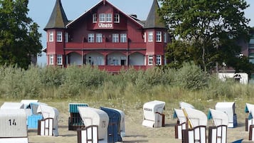 A large red building with a sign 'Vineta' on the facade, surrounded by beach huts.