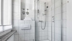 Ein modernes Badezimmer mit einer Duschkabine, einer Toilette und einem Waschbecken.