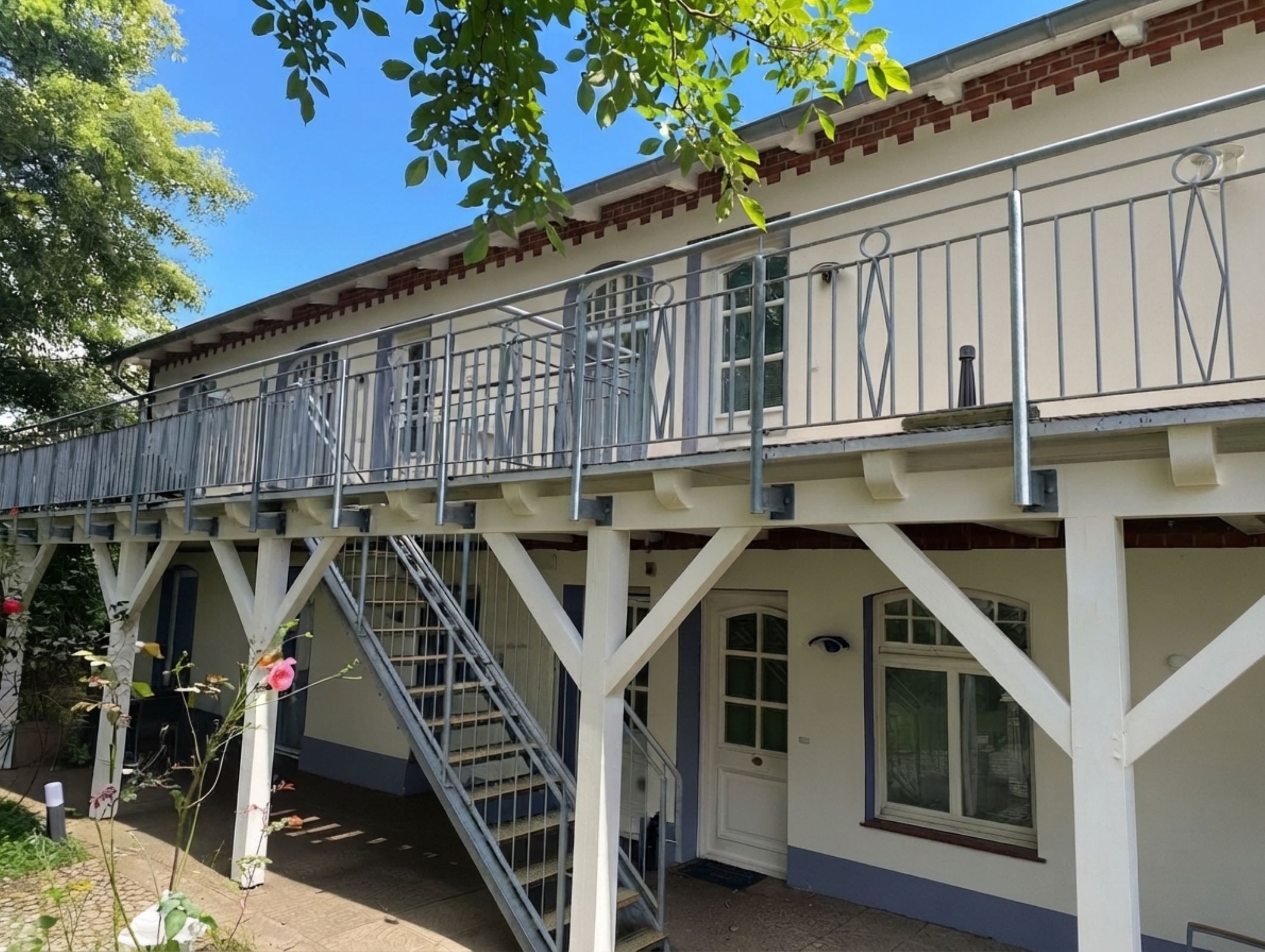 Ein zweistöckiges Gebäude mit Balkon, Treppe und einer Tür.