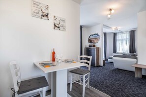 Una habitación moderna y bien iluminada con comedor, sala de estar y cocina.
