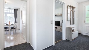 En gang med spiseområde, et spejl og et fjernsyn.