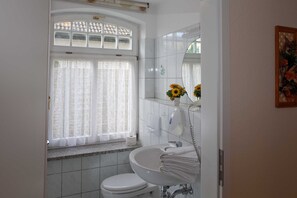 Een haardroger, handdoeken, zeep, toiletpapier
