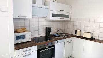 Een koffiezetapparaat/waterkoker, een koelkast, een microgolfoven
