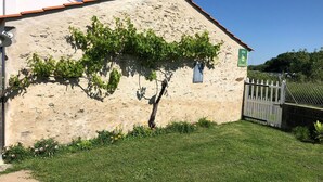 Un bâtiment en pierre avec un toit en pente, une petite fenêtre et une enseigne indiquant un site.