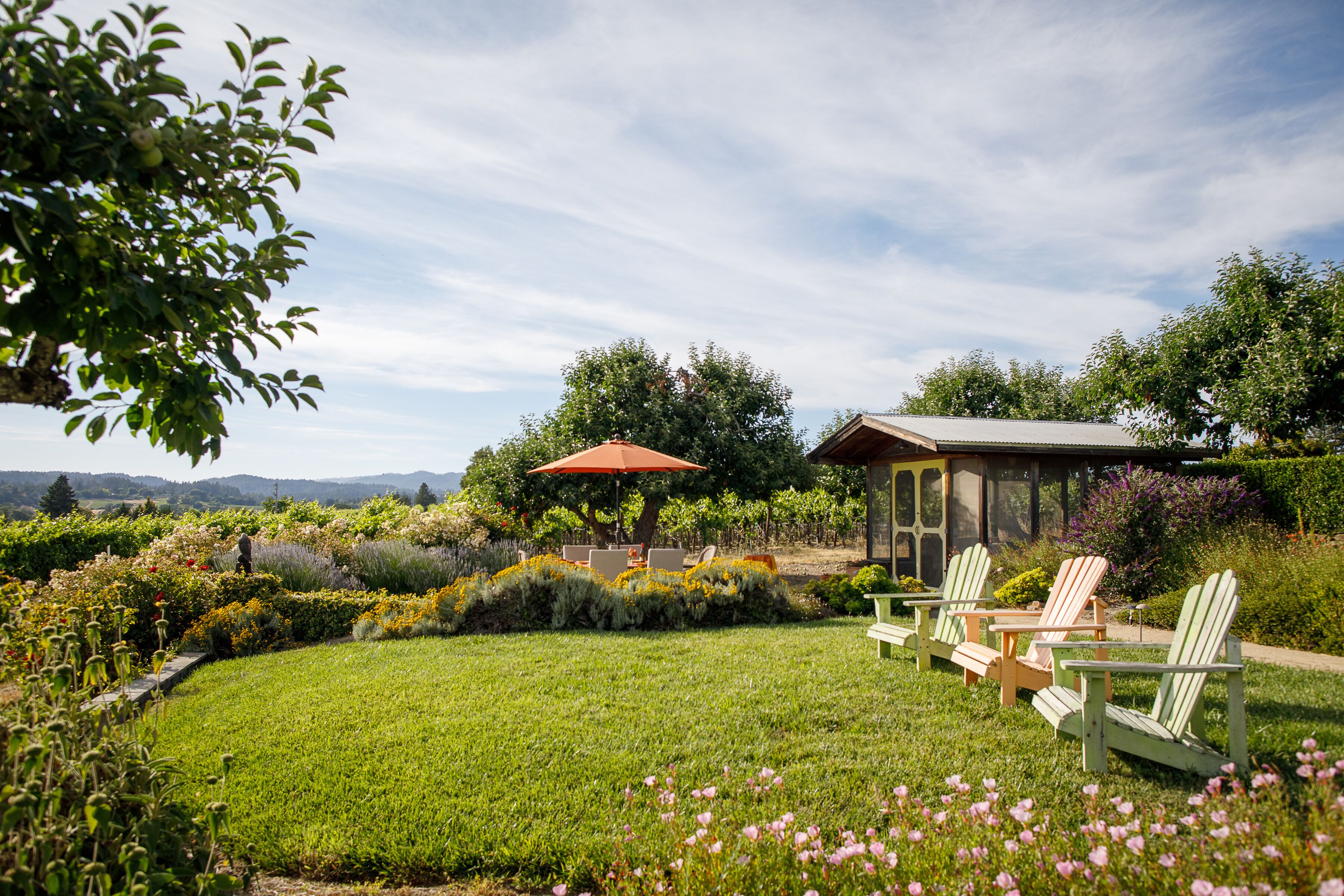 A garden with green lawn, outdoor seating, and a gazebo.