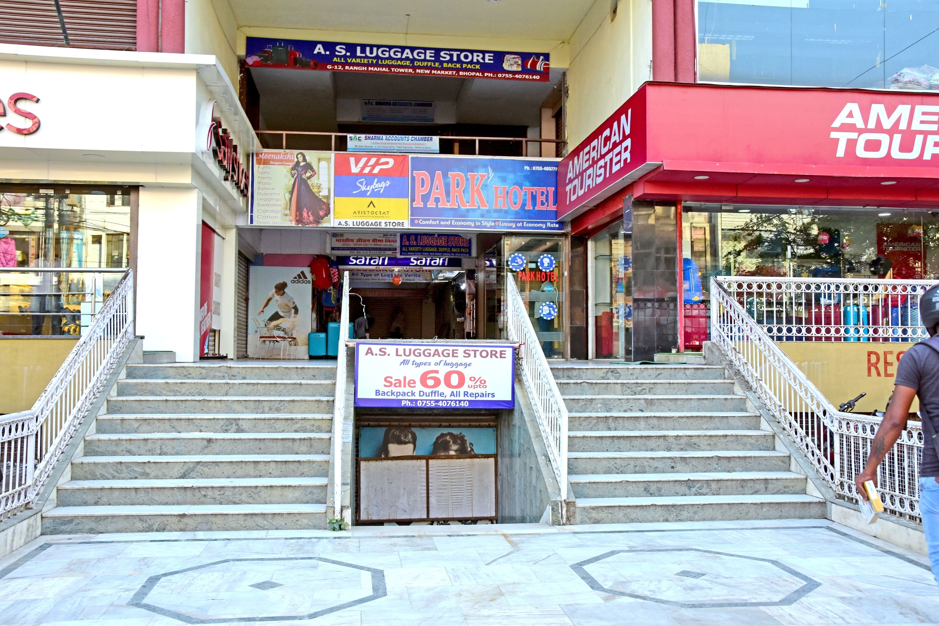 A hotel entrance with a sign for A.S. Luggage Store offering a 60% discount on backpacks and duffle bags.