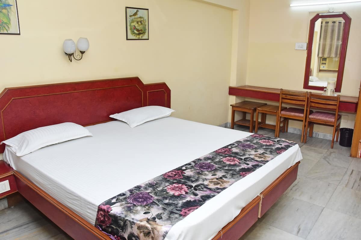 Un dormitorio con una cama, un escritorio y un espejo.