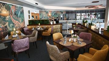 A restaurant with a bar area, seating with patterned chairs, a counter with a menu, and a decorative wall.