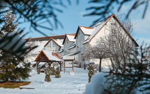 A hotel with multiple buildings, snow-covered roofs, and a clear sky. - Duroc Double Room - Marschall DuRoc Hotel**** (Markersdorf)