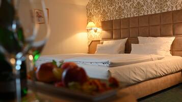 Een hotelkamer met een bed, een wandlamp en een schaal fruit op het nachtkastje.