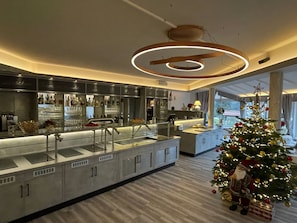 A modern kitchen with a bar area, a Christmas tree, and a star on the ceiling.