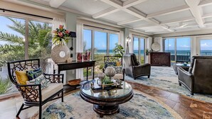 A spacious living room with a large glass coffee table, comfortable seating, and a view of the ocean. - Unbelievable Oceanfront Home, 6 bed/8 bath, 3036 S. Fletcher, Private Pool (Fernandina Beach)