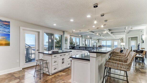 A spacious kitchen with white cabinetry, a large island, and a view of the ocean. - Unbelievable Oceanfront Home, 6 bed/8 bath, 3036 S. Fletcher, Private Pool (Fernandina Beach)