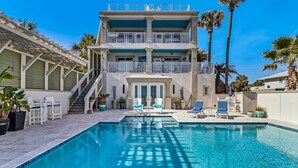 A two-story building with a swimming pool, outdoor seating, and palm trees. - Unbelievable Oceanfront Home, 6 bed/8 bath, 3036 S. Fletcher, Private Pool (Fernandina Beach)
