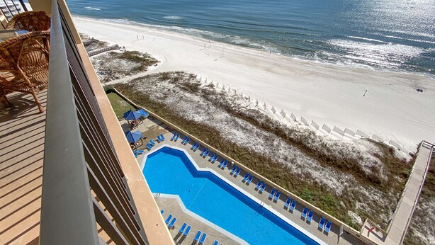 A pool area with blue lounge chairs and a view of the beach and ocean. - BEAUTIFUL BEACHFRONT CONDO, FAMILY AMENITIES, GREAT GULF VIEWS! (Orange Beach)