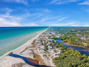 En kuststad med en strand, hus och en flod.