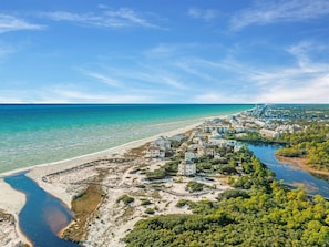 A coastal resort with beachfront properties, a river, and a clear blue sky.
