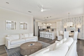 A modern living room with a sofa, coffee table, and a kitchen area with a bar.