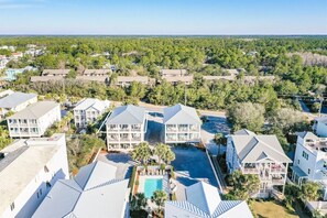 A resort with multiple buildings, a swimming pool, and a view of the surrounding forest.