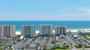 A hotel complex with multiple high-rise buildings, a parking lot, and a view of the ocean. - Windward Pointe 502-Beachfront 3bd/2ba-Sleeps 8-Heart of Orange Beach (Orange Beach)