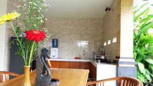 Una mesa de comedor de madera con un jarrón de flores y una escultura decorativa.