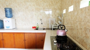 Una cocina con pileta, estufa y dispensador de agua.