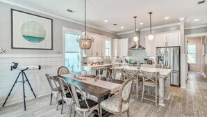 A spacious kitchen with a central island, white cabinetry, and stainless steel appliances.