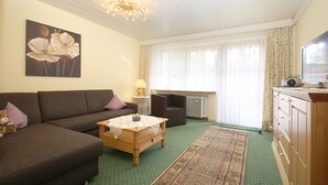 Ein Wohnzimmer mit einer Couch, einem Couchtisch, einer Lampe, einer Heizung und einem Fernseher.