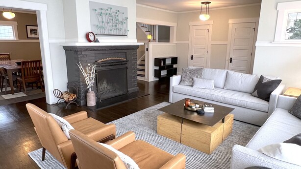 Una sala de estar moderna con chimenea, un conjunto de sofás y una mesa de centro.