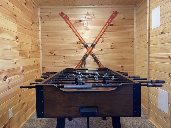 Una mesa de fútbol en una habitación de madera con techos altos.