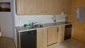 Una cocina con armarios de madera, lavavajillas y fregadero.