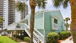 A two-story house with a porch and a staircase leading to the upper level. - Gulf view condo - Now Incl. Beach Service  (Miramar Beach)