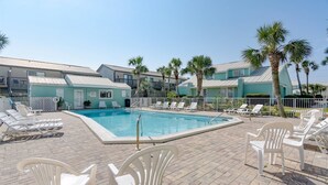 A pool area with lounge chairs and a pool. - Gulf view condo - Now Incl. Beach Service  (Miramar Beach)